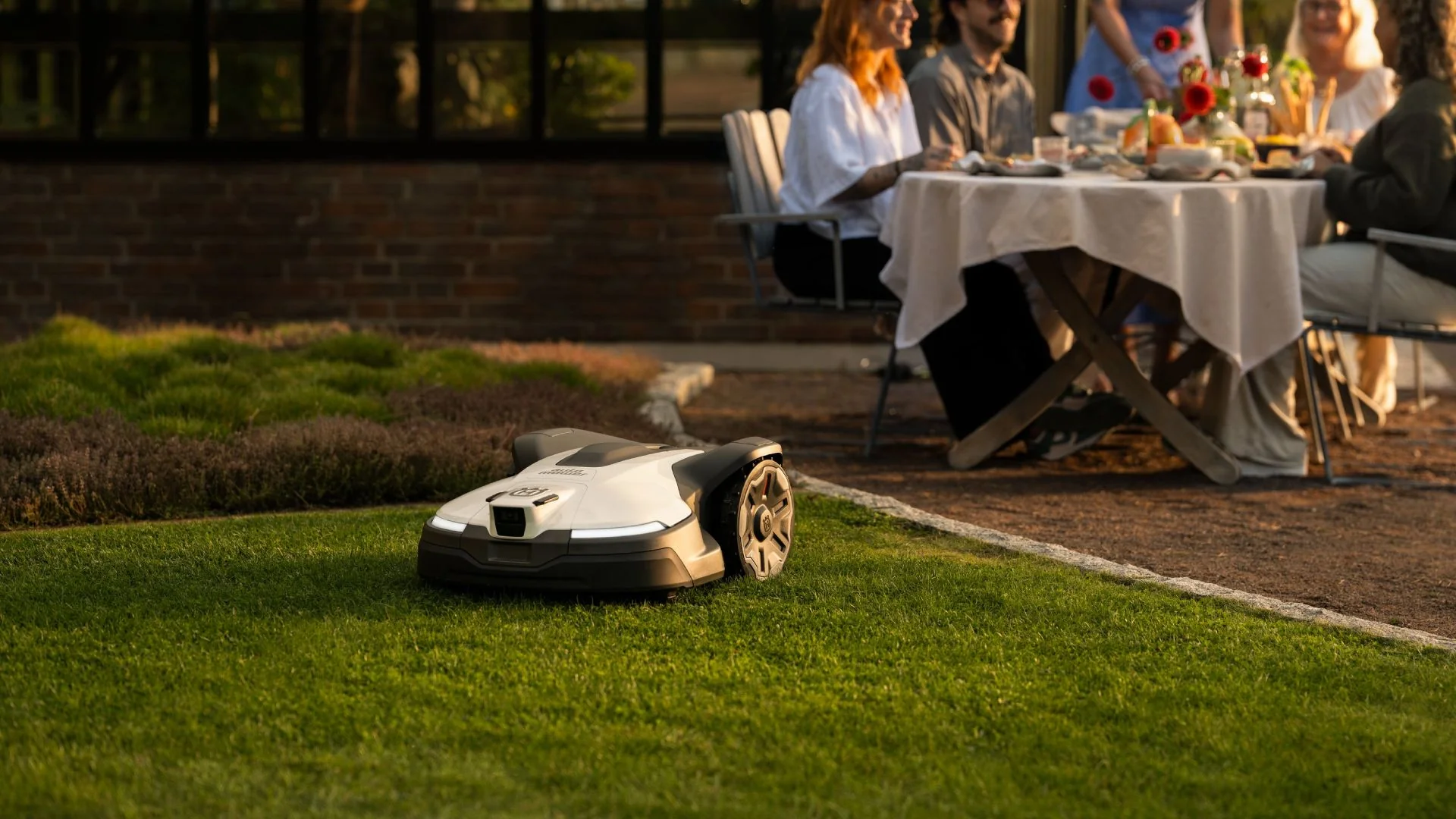 Husqvarna robotgräsklippare på välskött gräsmatta – Munkfors Trädgårdstjänst